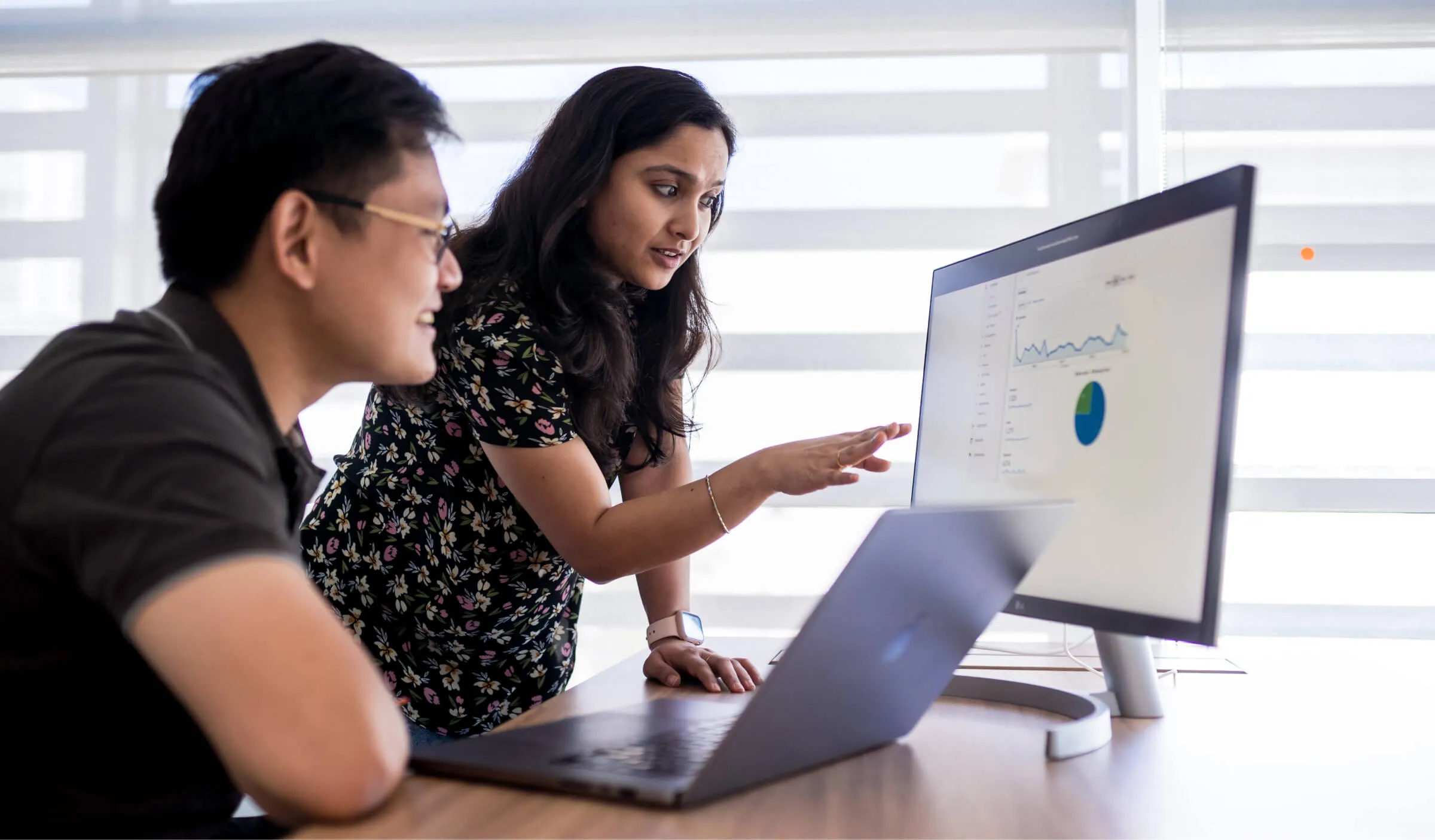 Two business intelligence members looking at a computer