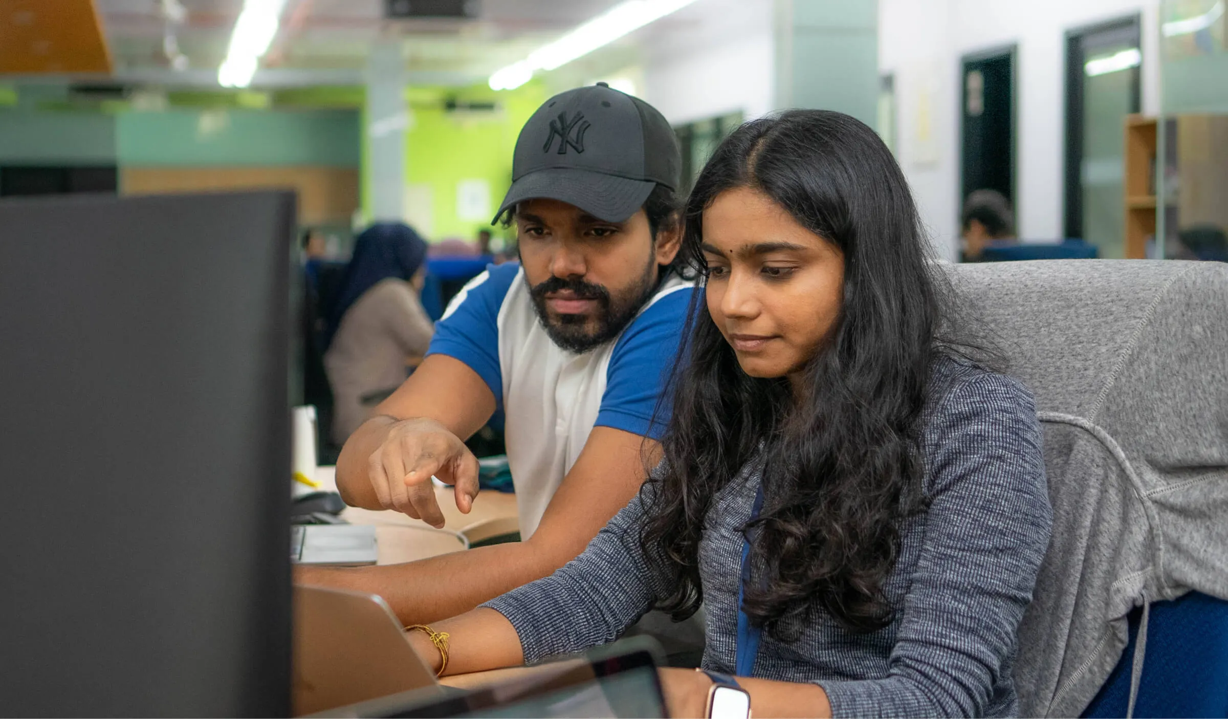 The business excellence team working on a computer together