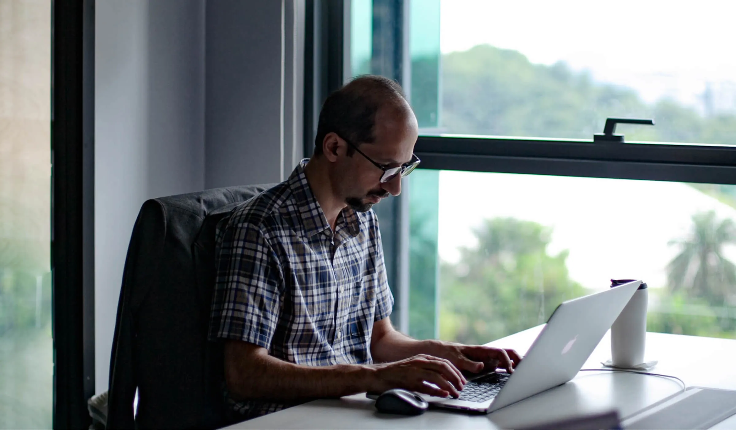 A Deriv employee working on his laptop