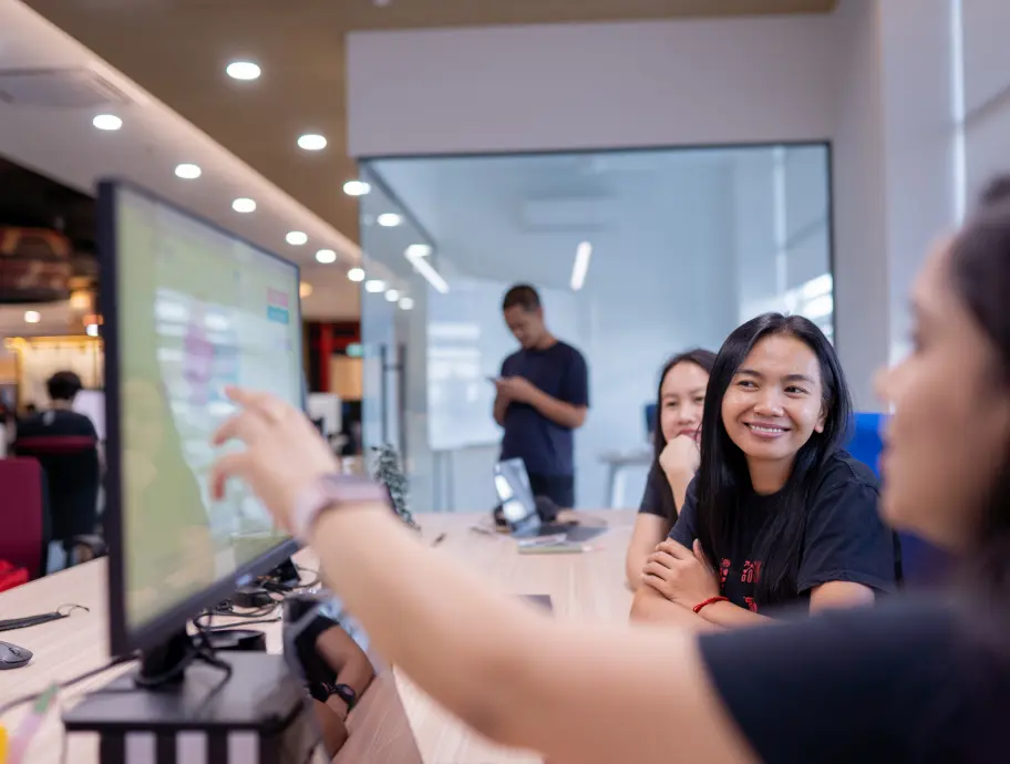 Deriv marketing team looking at a computer