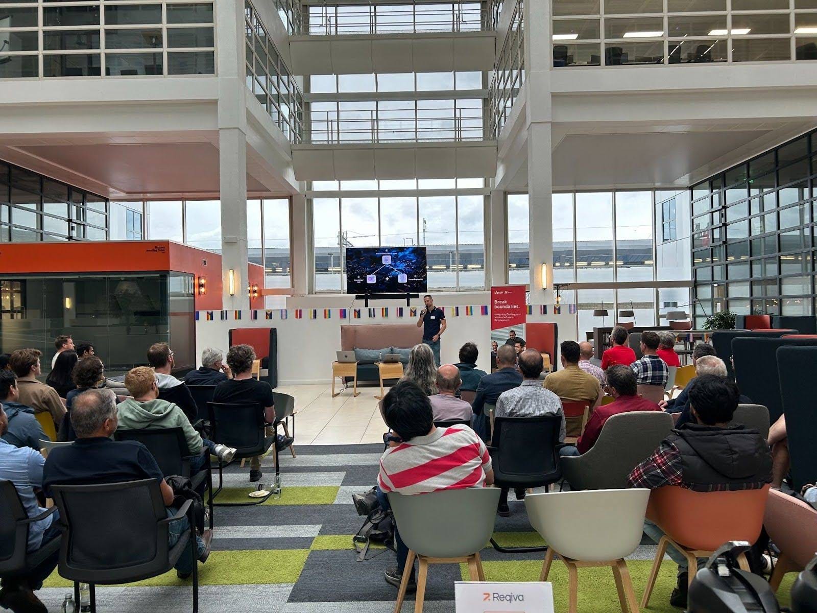 Attendees at the Deriv UK tech event, listening attentively to a speaker in a modern auditorium