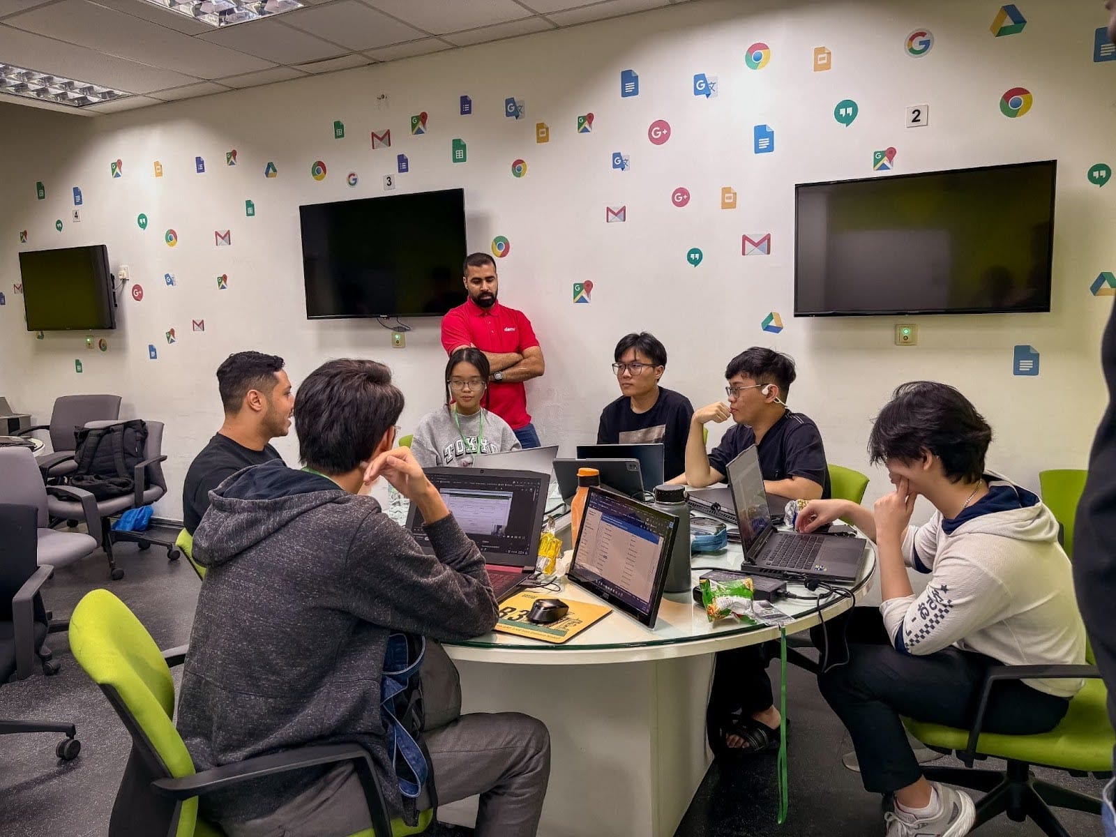 Deriv's Youssef Morad watches over the group he's mentoring as they discuss their project