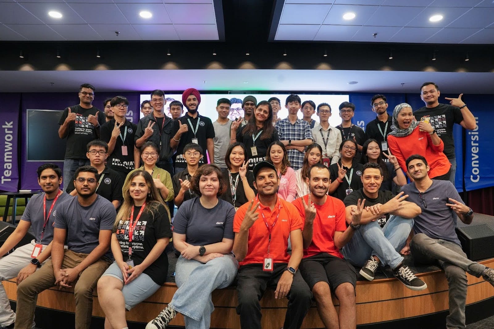 A group photo of the Deriv team and members of INTI’s IT Society, all smiling and posing together.